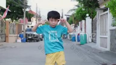 八岁的亚洲男孩在房子周围的小巷里跳舞。 快乐的<strong>时刻</strong>，有趣的<strong>时刻</strong>，欢笑的<strong>时刻</strong>